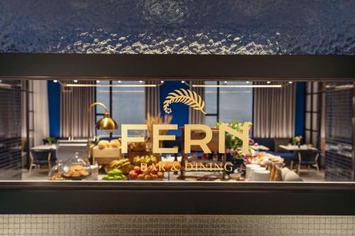 a store window with aeat dining sign on it at Hotel Indigo Melbourne Little Collins in Melbourne