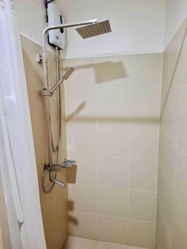 a shower in a bathroom with a glass door at City Escape in Manila