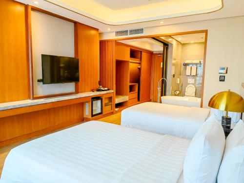 a hotel room with two beds and a flat screen tv at Best Western Plus Metro Clark in Angeles