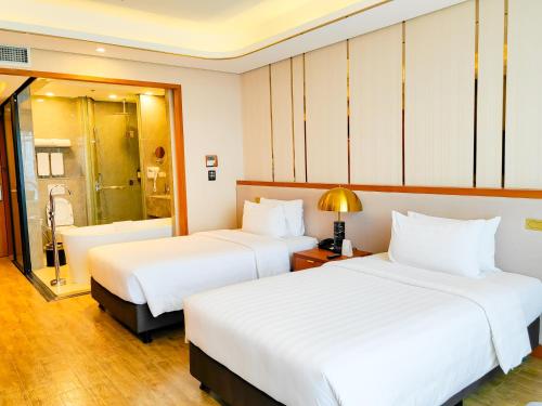 a hotel room with two beds and a shower at Best Western Plus Metro Clark in Angeles