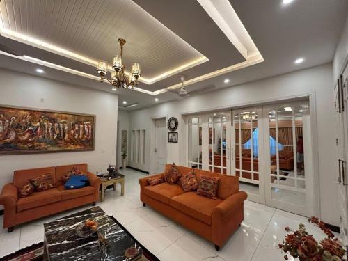 a living room with two couches and a chandelier at Holiday Inn islamabad in Islamabad