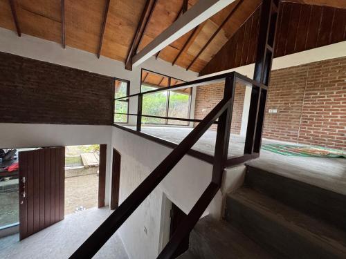 a staircase in a house with a brick wall at Lentera Lombok in Tetebatu