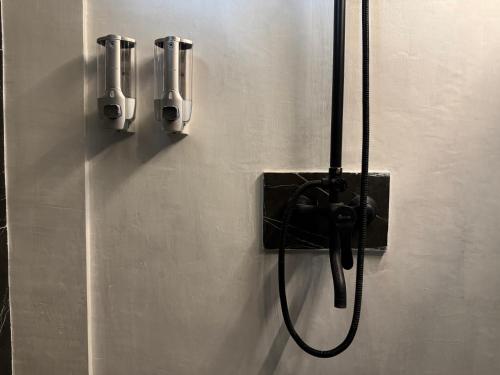 a shower with a hose attached to a wall at Lentera Lombok in Tetebatu