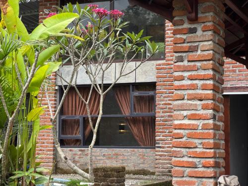 a brick building with a black door with a window at Lentera Lombok in Tetebatu