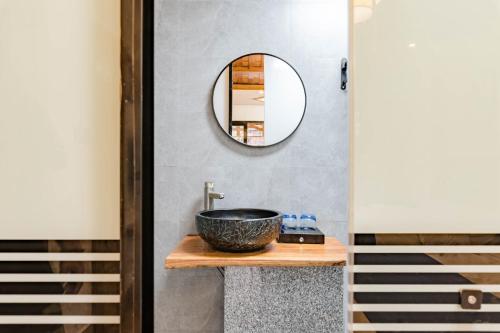 WangcunにあるFloral Hotel Furong Town Qichi Innの洗面台と鏡のあるバスルーム