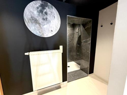 a bathroom with a shower and a moon on the wall at Capsule Moonlight - Jacuzzi - Sauna - Ecran 100" - PS5 in Mons
