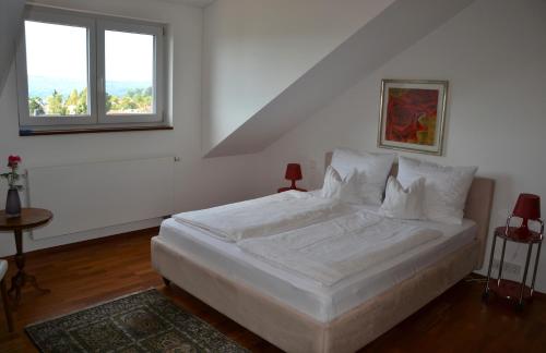 een wit bed in een kamer met een raam bij Ferienwohnung Am Bergle in Überlingen
