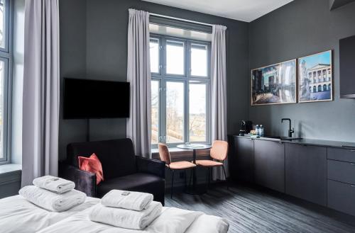 a bedroom with a bed and a chair and a window at Hotel Filip in Oslo