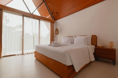 Un dormitorio con una cama grande y una ventana grande. en Kubu Wana Villa, en Uluwatu