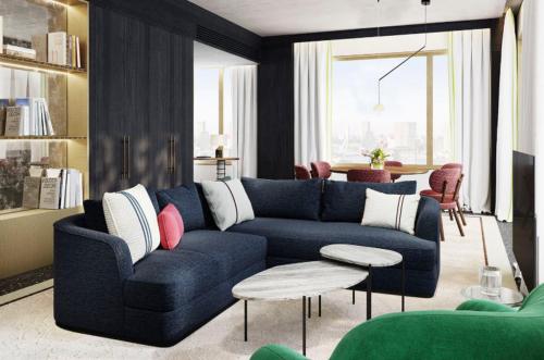 a living room with a blue couch and a table at Eurostars Rijnhaven in Rotterdam