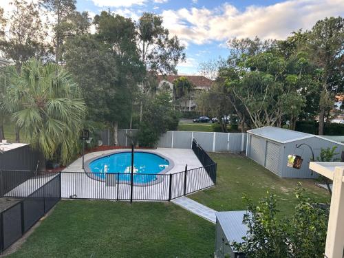 a swimming pool in a yard with a fence at One Bedroom with shared bathroom and kitchen in Gold Coast