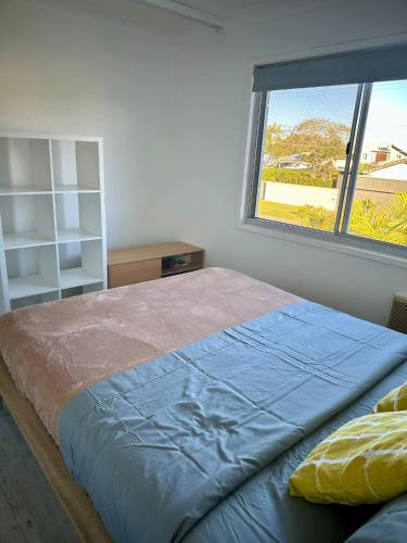 a bedroom with a large bed with a window at One Bedroom with shared bathroom and kitchen in Gold Coast