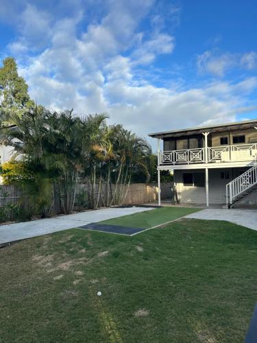 a house with a porch and a yard at One Bedroom with shared bathroom and kitchen in Gold Coast