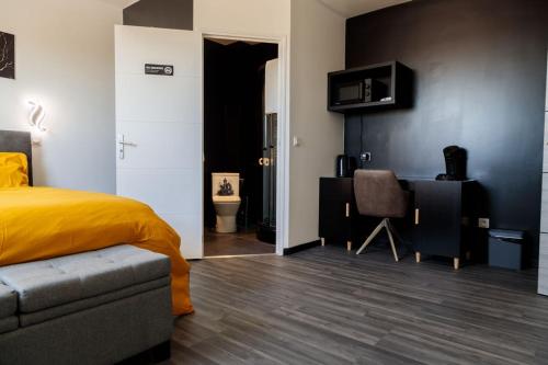 a bedroom with a bed and a desk and a chair at SEE - Gare de Marly in Valenciennes