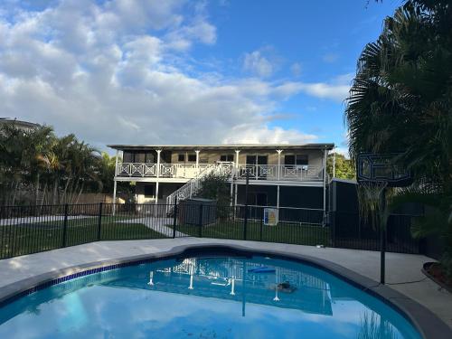 a swimming pool in front of a house at One Bedroom with shared bathroom and kitchen in Gold Coast