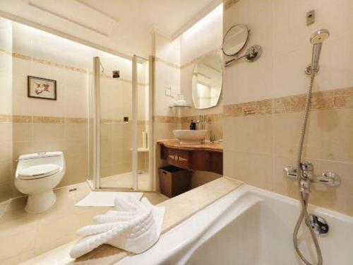 a bathroom with a tub and a toilet and a sink at Quanzhou Hotel in Quanzhou