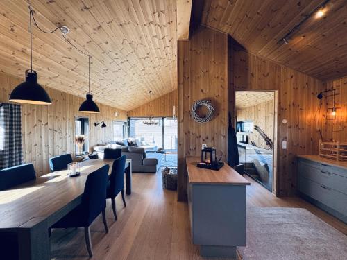 una cucina e un soggiorno con un lungo tavolo e sedie di Moderne leilighet i Vestlia-Ski in ski out a Geilo