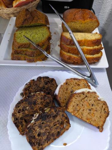 Onet le ChâteauにあるHôtel Le Laury'sのテーブルの上にケーキとパンが載った白い皿