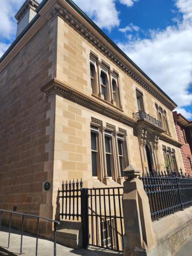 a brick building with a fence in front of it at The Macquarie Hobart in Hobart