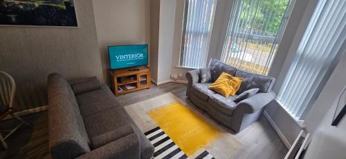 a living room with a couch and a television at Alexandra Park Apartments in Belfast