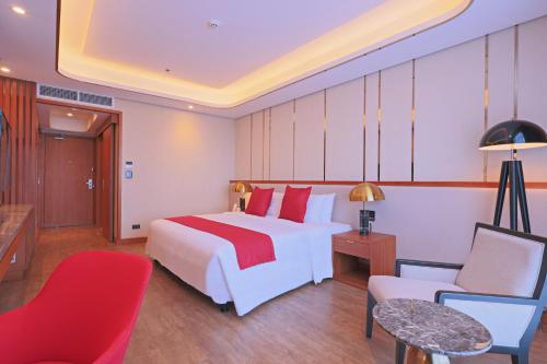 a hotel room with a white bed and red pillows at Best Western Plus Metro Clark in Angeles