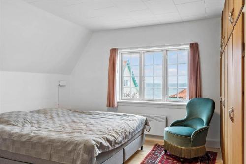 a bedroom with a bed and a chair and a window at 1278-N-Liseleje-Kystvej-12 in Liseleje