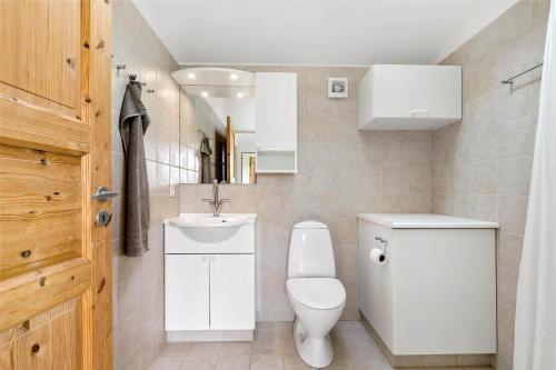a white bathroom with a toilet and a sink at 1278-N-Liseleje-Kystvej-12 in Liseleje