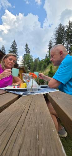 a man and a woman sitting at a picnic table at Józefina Apartament's blisko centrum in Szklarska Poręba
