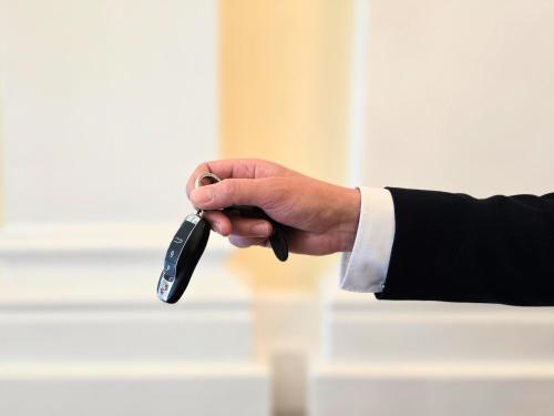 a person in a suit holding a remote control at Hotel Kaiserhof Wien in Vienna