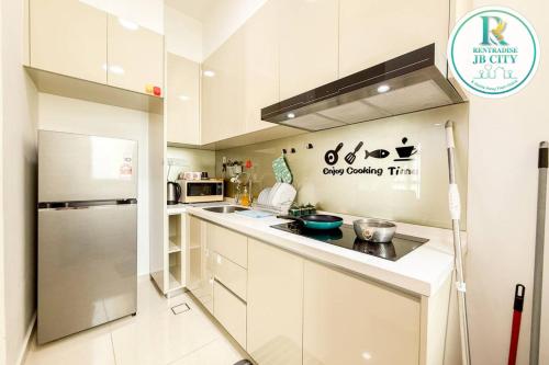 a kitchen with white cabinets and a stainless steel refrigerator at Skudai Paradigm Mall by RR JBcity in Johor Bahru