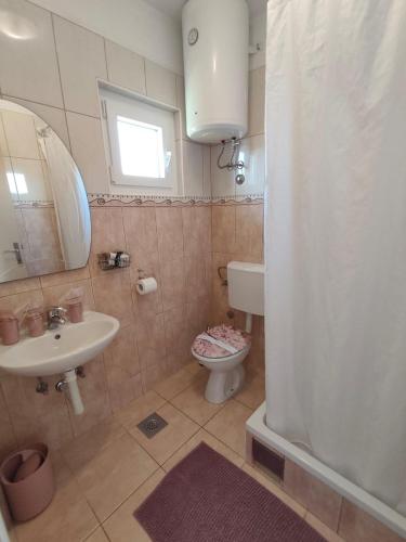 a bathroom with a sink and a toilet and a mirror at Apartments Lans in Vodice