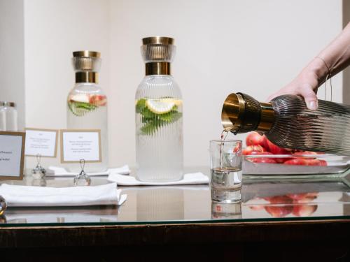a person pours a drink into a glass at Hotel Kaiserhof Wien in Vienna