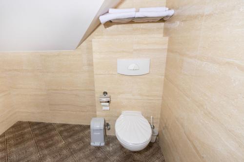 a bathroom with a white toilet in a room at Hotel Victory Home in Warsaw