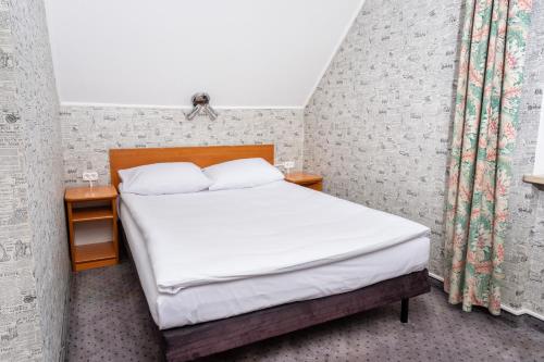 a bedroom with a bed with white sheets at Hotel Victory Home in Warsaw