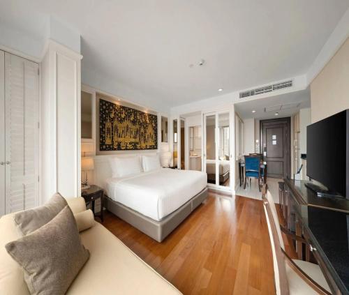 a bedroom with a white bed and a couch at Hotel Admiral Near Delhi Airport in New Delhi