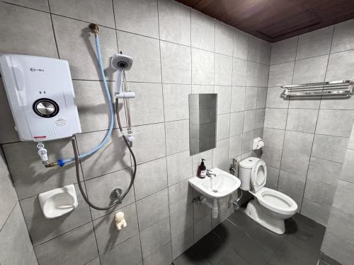 a bathroom with a shower with a toilet and a sink at The Nest Cameron Homestay in Tanah Rata