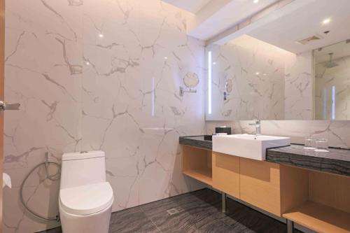 a bathroom with a white toilet and a sink at Best Western Plus Metro Clark in Angeles