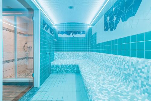 a blue tiled bathroom with a large tub with blue tiles at Vallorcine Mont Blanc Spa in Vallorcine