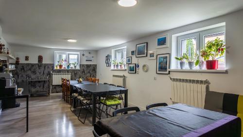 a dining room with a table and chairs and windows at Villa Marina in Augustów