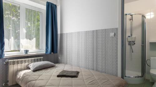 a bedroom with a bed and a shower and a window at Villa Marina in Augustów