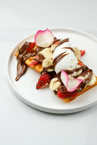 a white plate with a dessert with ice cream and strawberries at Sunset Apart-Hotel in Yerevan