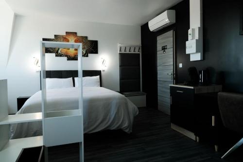 a hotel room with a bed and a mirror at SEE - Gare de Marly in Valenciennes