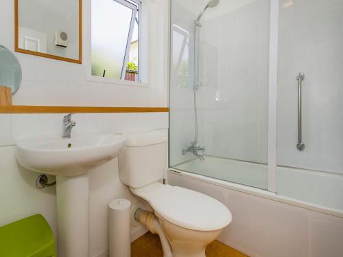 a bathroom with a toilet and a sink and a shower at Gone Coastal - Whangamata Holiday House in Whangamata