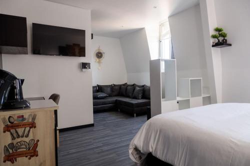 a hotel room with a bed and a couch at SEE - Gare de Marly in Valenciennes