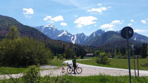a man and a child with a bike on a dirt road at Apartma Maržič in Kranjska Gora