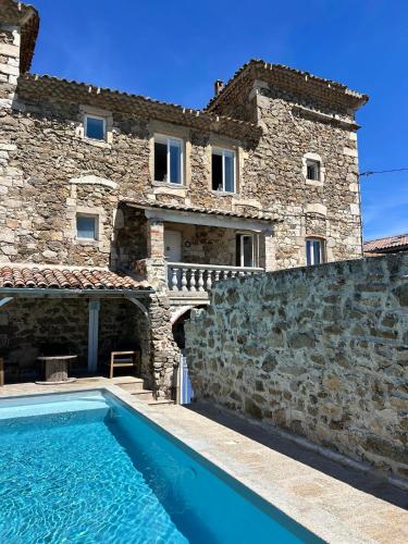 una casa con piscina delante de un edificio en Gite du Chateau, en Éclassan