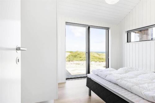 a bedroom with a bed with a view of the ocean at LK1240-Lokken-Rosavej-13 in Løkken