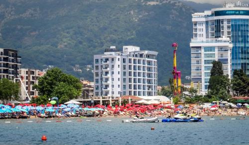 a crowd of people on a beach with buildings at Luxury Budva Center Apartments in Budva