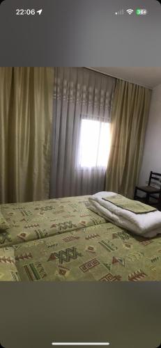 a bed with a blanket on it with a window at Vila Cano Boutique in Durrës