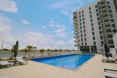 a swimming pool in front of a building at Silk Valley - Waterfront 2B near Yas attractions in Yas Island